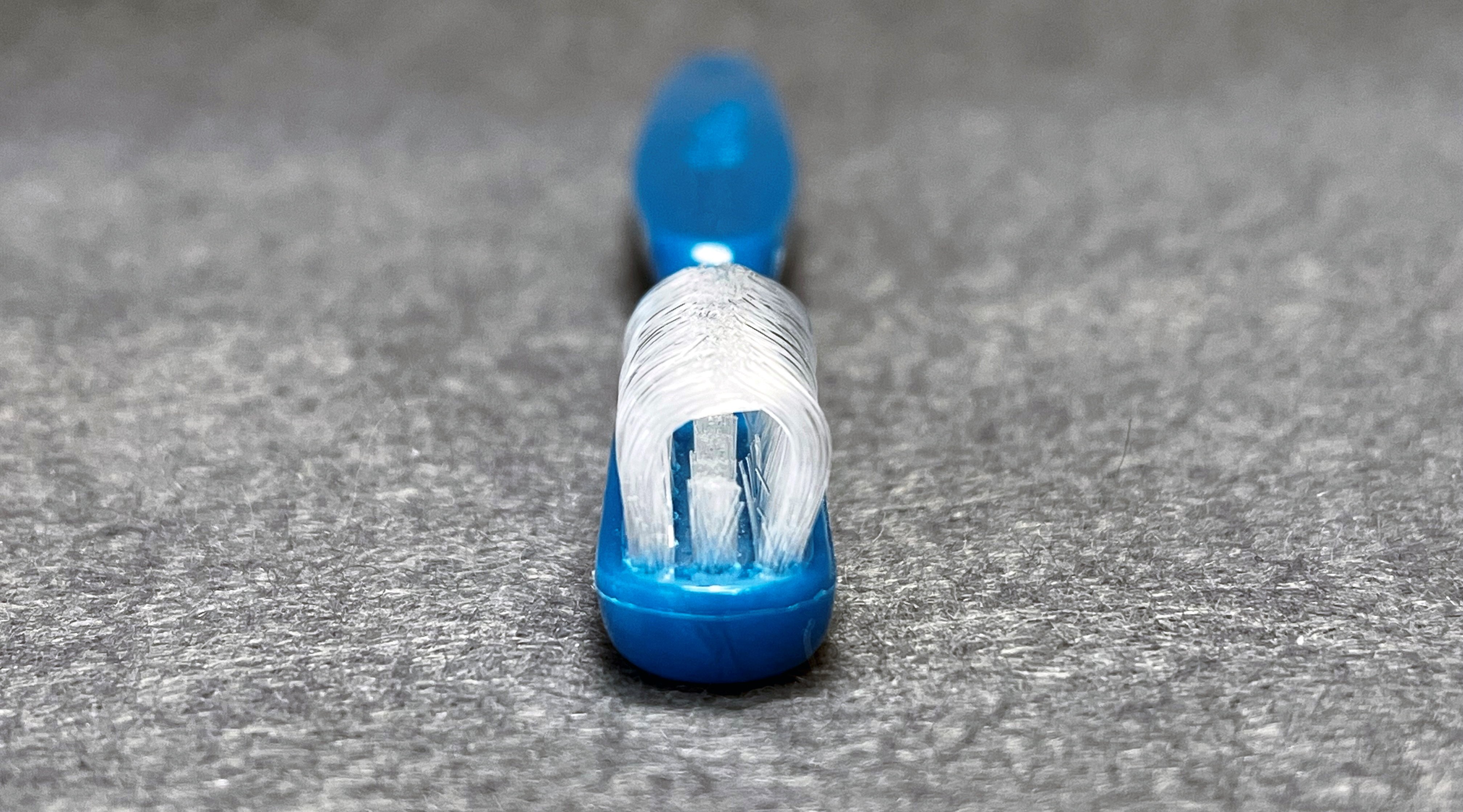 Dubbeltandborsten Collis Curve som rengör tändernas utsidor, insidor och tuggytor samtidigt