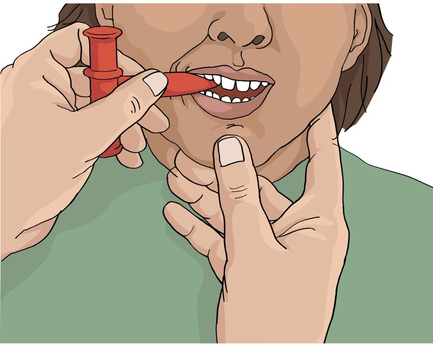 På bilden syns en person som med hjälp av någon annan biter på hjälpmedlet chey tube, tuggtub.
